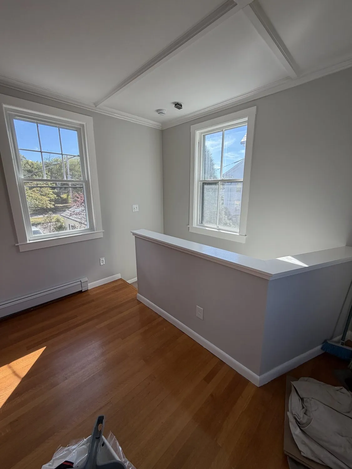 A Danvers dining room painted soft gray, with a white coffered ceiling and deep window casings